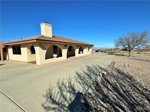 exterior space featuring a chimney and stucco siding