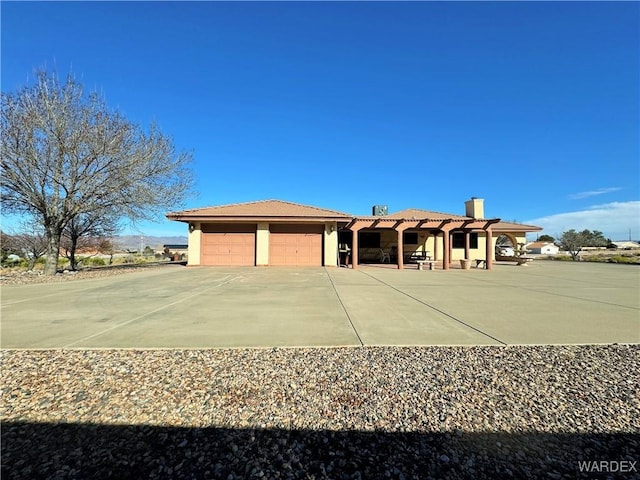 view of front of property with a tiled roof, a chimney, and stucco siding