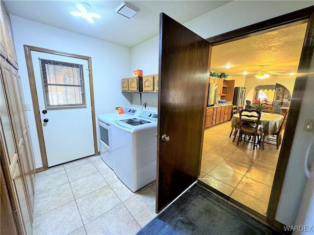 laundry area featuring light tile patterned floors, ceiling fan, washing machine and clothes dryer, and cabinet space