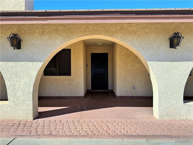 doorway to property with a patio and stucco siding