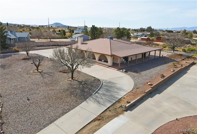 view of front of house featuring a tile roof, a mountain view, and driveway