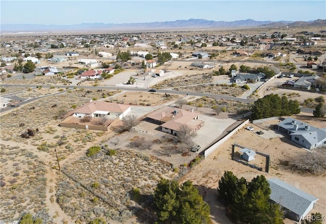 birds eye view of property featuring view of desert, a residential view, and a mountain view