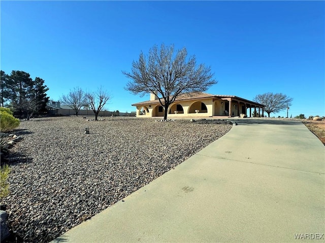 view of front facade with driveway and fence