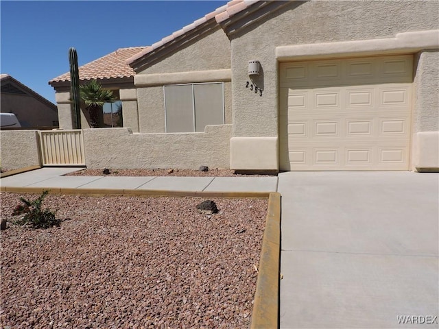 2353 Halfmoon Way, Bullhead City, AZ 86442 - view of front of property featuring an attached garage, driveway, a tile roof, and stucco siding