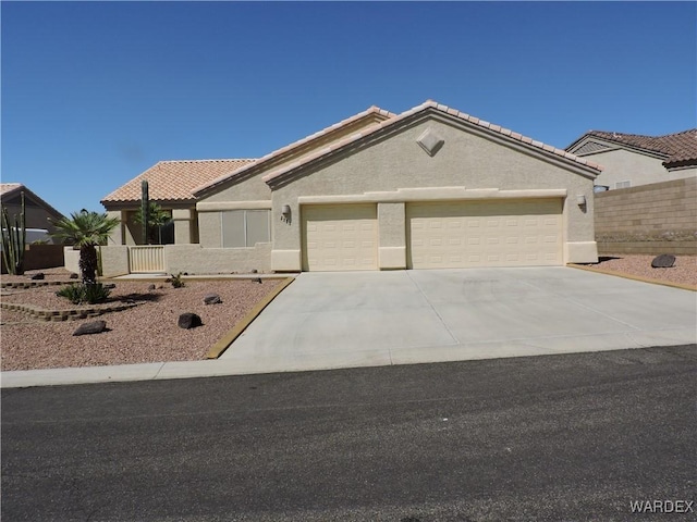 2353 Halfmoon Way, Bullhead City, AZ 86442 - single story home featuring a garage, stucco siding, concrete driveway, and a tiled roof