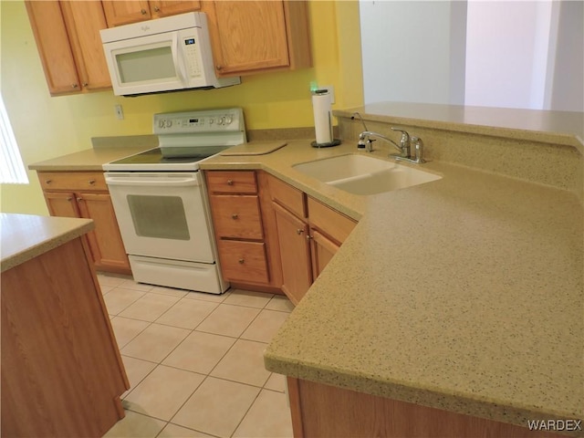 2353 Halfmoon Way, Bullhead City, AZ 86442 - kitchen with a sink, light countertops, light tile patterned floors, a peninsula, and white appliances