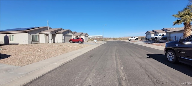 view of road with sidewalks, a residential view, and curbs