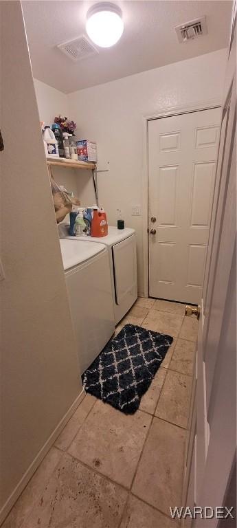 laundry area with laundry area, separate washer and dryer, light tile patterned flooring, and visible vents