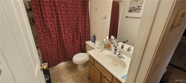 bathroom with stone tile flooring, vanity, and toilet