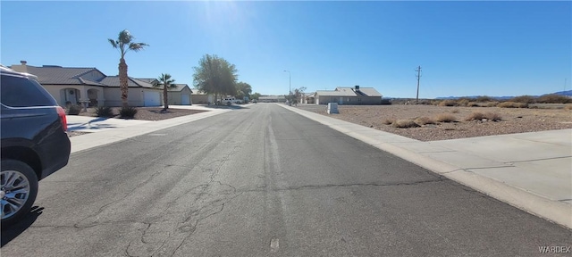 view of street with a residential view, curbs, and sidewalks