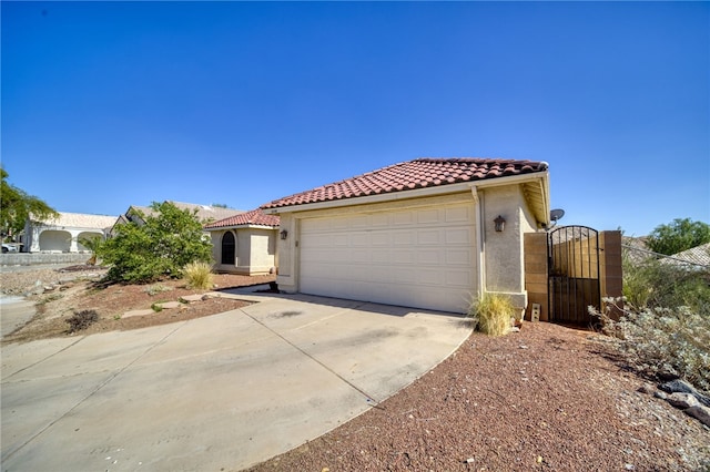 2230 Diamond Creek Rd, Bullhead City, AZ 86442 - mediterranean / spanish home featuring a tile roof, a garage, stucco siding, and driveway