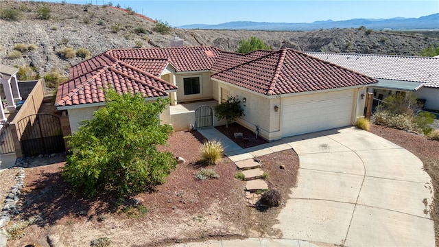 2230 Diamond Creek Rd, Bullhead City, AZ 86442 - mediterranean / spanish home featuring a gate, a tiled roof, a garage, driveway, and a mountain view