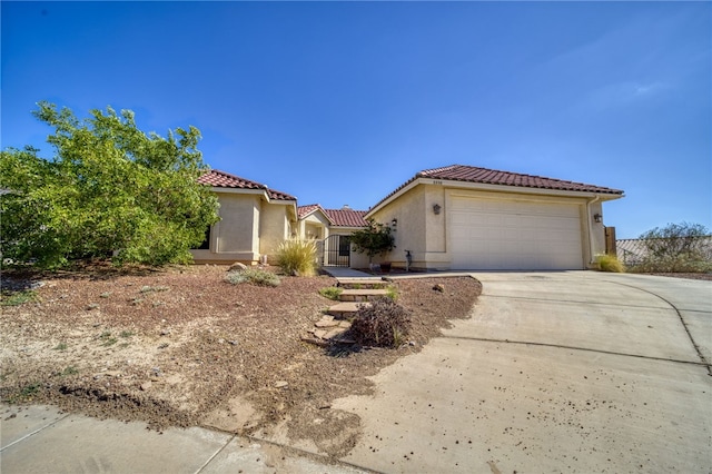 2230 Diamond Creek Rd, Bullhead City, AZ 86442 - mediterranean / spanish house with an attached garage, concrete driveway, stucco siding, and a tile roof