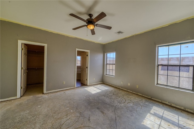 2230 Diamond Creek Rd, Bullhead City, AZ 86442 - unfurnished bedroom with a walk in closet, a ceiling fan, crown molding, and connected bathroom