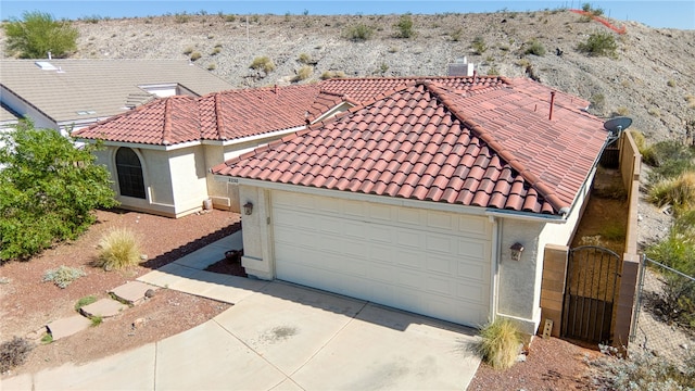 2230 Diamond Creek Rd, Bullhead City, AZ 86442 - mediterranean / spanish-style home with a tiled roof, concrete driveway, a gate, stucco siding, and an attached garage