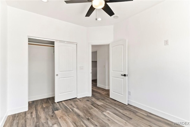 unfurnished bedroom featuring a closet, baseboards, ceiling fan, and wood finished floors