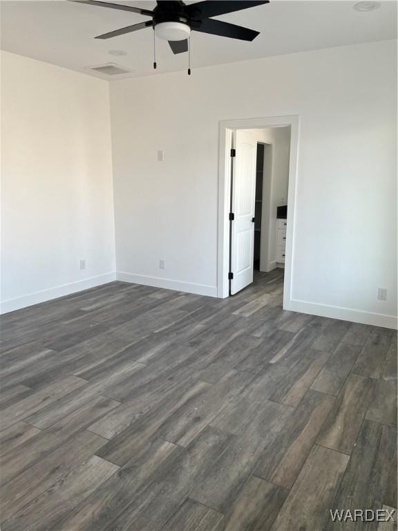 empty room with dark wood-type flooring, baseboards, and a ceiling fan