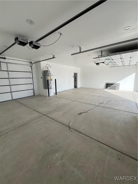 garage with a garage door opener and electric water heater