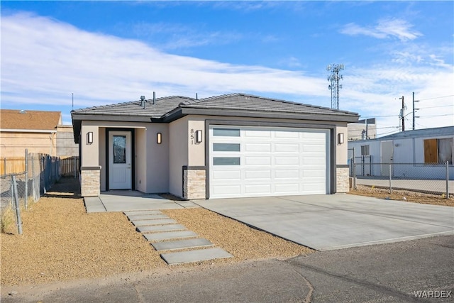 view of front facade featuring a garage, concrete driveway, stone siding, fence, and stucco siding