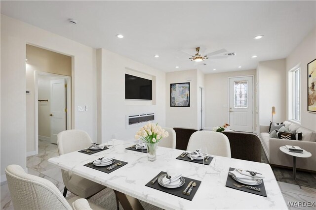 dining area with a ceiling fan, a glass covered fireplace, visible vents, and recessed lighting