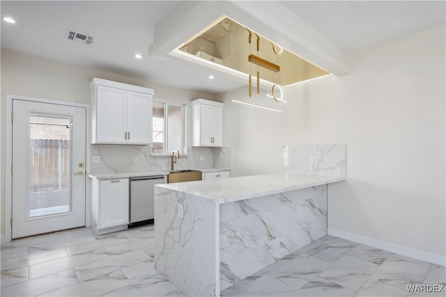 kitchen with marble finish floor, backsplash, white cabinets, dishwasher, and a peninsula