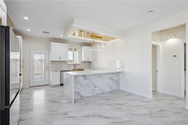 kitchen featuring white cabinetry, marble finish floor, stainless steel dishwasher, fridge, and decorative backsplash