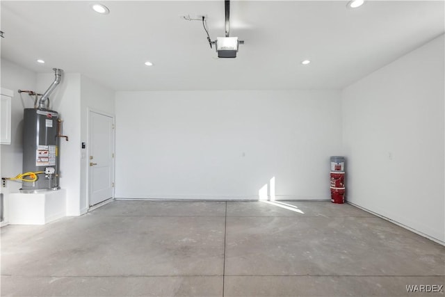 garage with a garage door opener, gas water heater, and recessed lighting