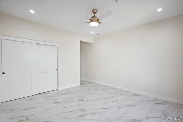 unfurnished bedroom featuring marble finish floor, a closet, and baseboards