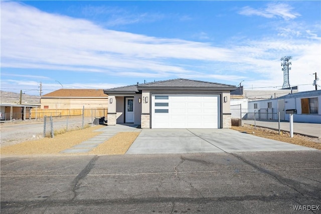 view of front of house featuring a garage, fence, concrete driveway, and stucco siding