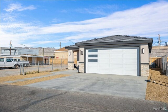 garage with fence and concrete driveway