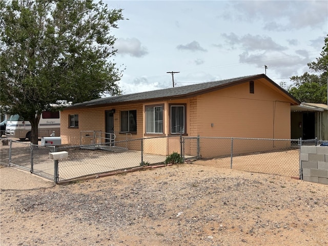 view of front of home with brick siding, fence, and a gate