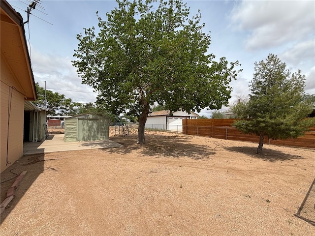 view of yard featuring a storage unit, fence, and an outdoor structure