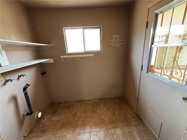 laundry area with laundry area and stone finish floor