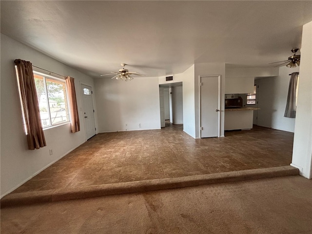 unfurnished living room with a ceiling fan and visible vents