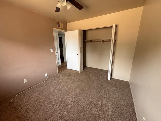 unfurnished bedroom featuring a closet, a ceiling fan, visible vents, and dark carpet
