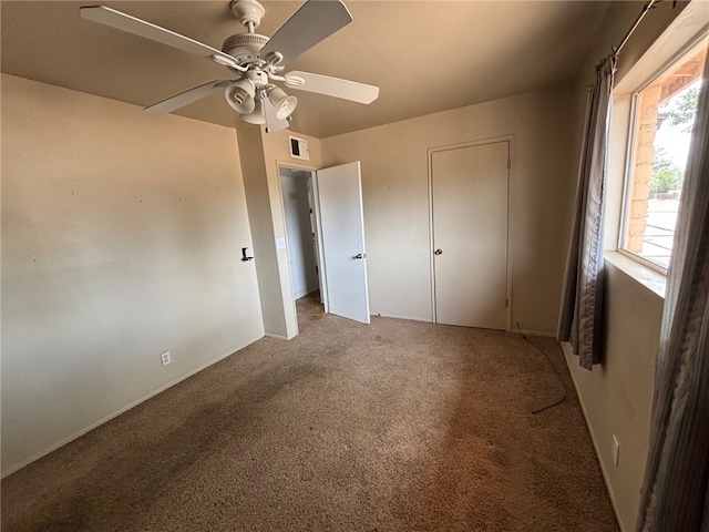 unfurnished bedroom featuring carpet, visible vents, baseboards, and ceiling fan