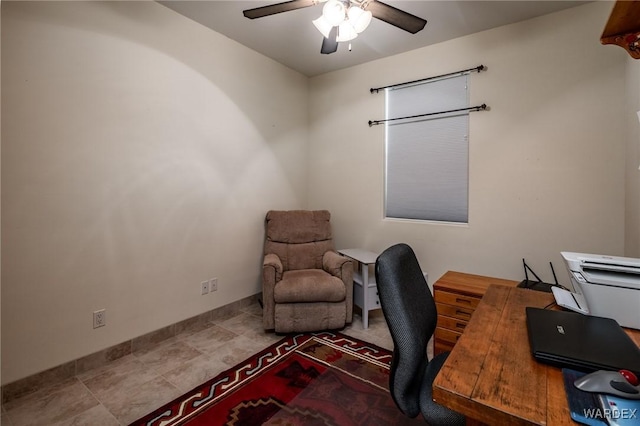 office space featuring ceiling fan and baseboards