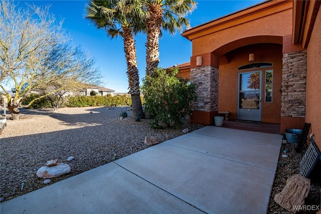 entrance to property featuring stone siding and stucco siding