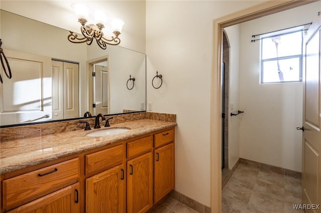 bathroom featuring an inviting chandelier, vanity, and baseboards