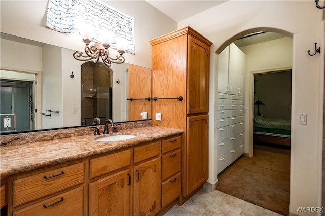 bathroom featuring a shower with door and vanity