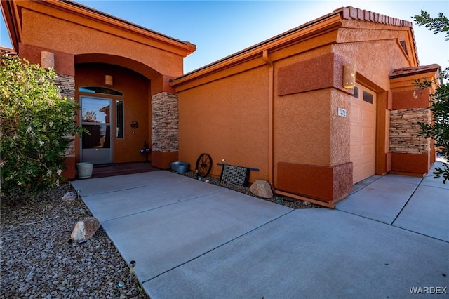 view of exterior entry featuring stone siding and stucco siding