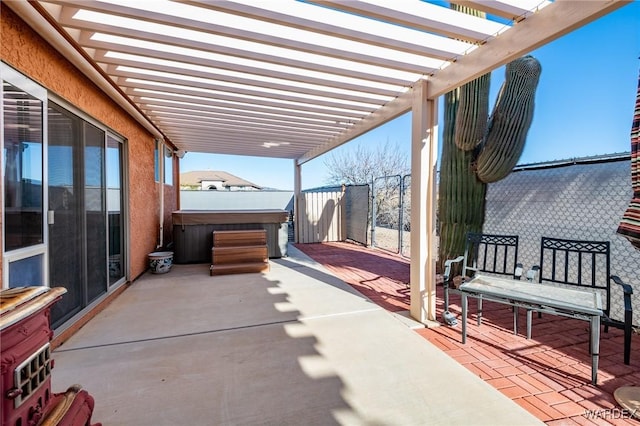 view of patio featuring a hot tub, fence, and a pergola