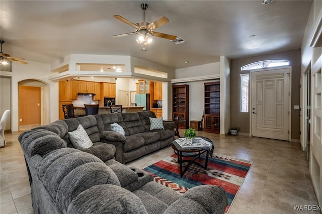 living room with visible vents, arched walkways, a ceiling fan, and light tile patterned flooring