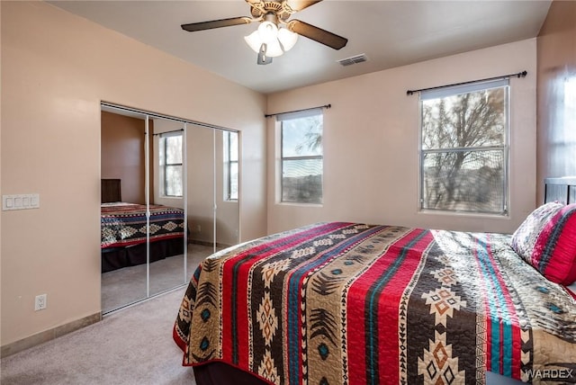 bedroom with ceiling fan, visible vents, baseboards, a closet, and carpet