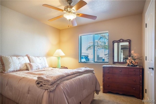 bedroom with light carpet and a ceiling fan