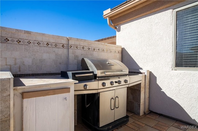 view of patio featuring exterior kitchen, area for grilling, and fence