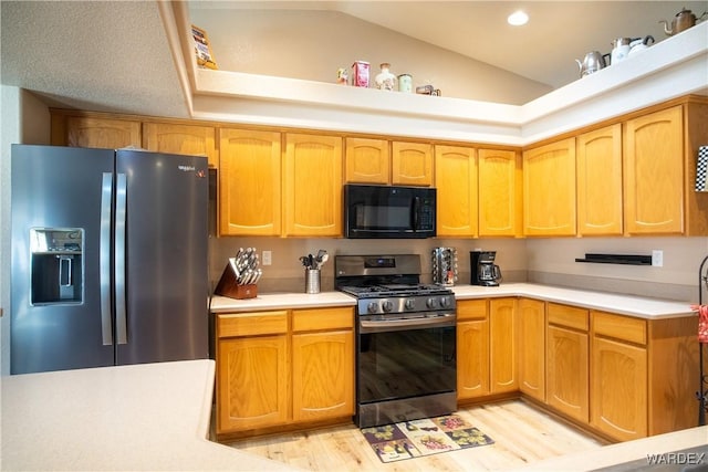 kitchen with recessed lighting, stainless steel appliances, light wood-style floors, vaulted ceiling, and light countertops