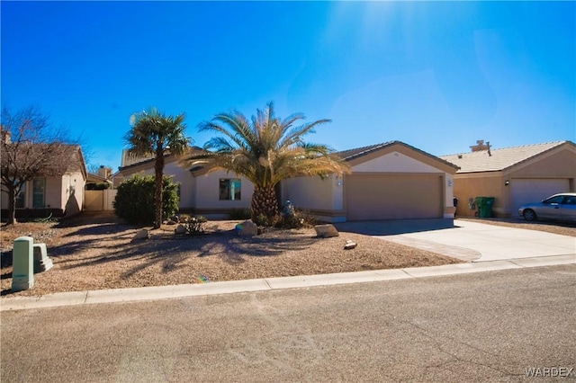 view of front facade featuring an attached garage, concrete driveway, and stucco siding