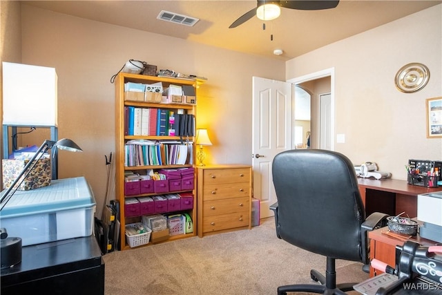 office featuring carpet, visible vents, and a ceiling fan