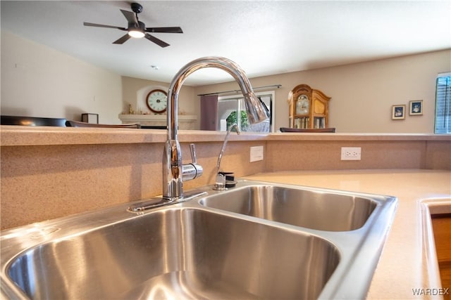 room details featuring a ceiling fan, light countertops, and a sink